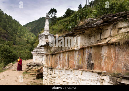 L'est du Bhoutan, la Vallée Village Lhuentse, Khoma, moine au mur mani et chorten Banque D'Images