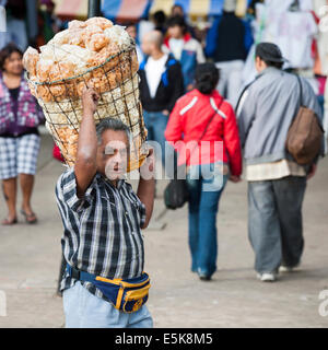 Snack-Man. Un vendeur de rue avec une pochette d'argent descend un immense bin de collations croustillantes sur son épaule sur la place centrale de Mérida Banque D'Images