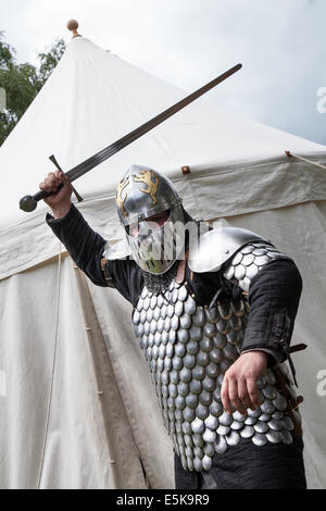 Un swordman armé dans une armure militaire complète avec un chain mail, une épée et un casque, un swordman, un combat d'épée, un guerrier, un homme, une arme, un chevalier médiéval, un chevalier traditionnel, des vêtements de protection, une martiale, un homme au château de Beeston à Cheshire, en Angleterre. Historia Normannis est un groupe de réédiction médiévale blindé datant du XIIe siècle sur le site du patrimoine anglais. Banque D'Images