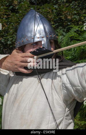 Archer prendre visent à Chester, Cheshire, Royaume-Uni 3 août, 2014. M. Dominic Tucker un longbow anglais archer avec un d'avant au tournoi de chevaliers médiévaux tenue au Château de Beeston Cheshire, Angleterre. Historia Normannis un 12ème siècle début de l'époque médiévale, l'exactitude, groupe de reconstitution se concentrer, fighter. archer, arc, arc, tir à l'arc, flèche, arme, cible, objectif, sport, tir, chasse, visant, précision, vector, Tournoi Warrior, chaîne-mail et fonctionnant à l'adrénaline des équipes d'archers armés hautement qualifiés et anglais knights répondre de front à l'English Heritage Site. Banque D'Images