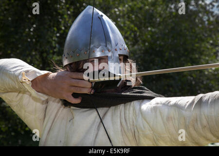 Archer prendre visent à Chester, Cheshire, Royaume-Uni 3 août, 2014. M. Dominic Tucker un longbow anglais archer avec un d'avant au tournoi de chevaliers médiévaux tenue au Château de Beeston Cheshire, Angleterre. Historia Normannis un 12ème siècle début de l'époque médiévale, l'exactitude, groupe de reconstitution se concentrer, fighter. archer, arc, arc, tir à l'arc, flèche, arme, cible, objectif, sport, tir, chasse, visant, précision, vector, Tournoi Warrior, chaîne-mail et fonctionnant à l'adrénaline des équipes d'archers armés hautement qualifiés et anglais knights répondre de front à l'English Heritage Site. Banque D'Images