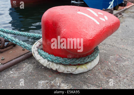 Close-up d'une corde d'amarrage avec une extrémité nouée autour d'un crochet attaché sur une jetée en bois/ amarre Nautique Banque D'Images