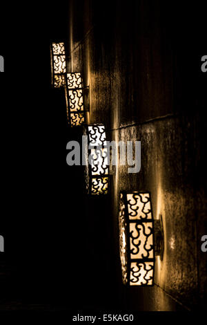 Quatre alignés des lumières décoratives de la réflexion sur un mur de pierre. Banque D'Images