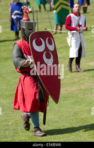 Chester, Cheshire, Royaume-Uni 3 août, 2014. La reconstitution médiévale armés casqués avec Chauffage ou chauffage du bouclier bouclier en forme. Une cité médiévale Chevalier blindé, la défense contre le vol des flèches, au Tournoi qui a eu lieu au Château de Beeston Cheshire, Angleterre. Historia Normannis un début 12ème siècle reconstitution médiévale groupe prévu par la poste à la chaîne et l'adrénaline en équipes de chevaliers avec hautement qualifiés à s'est réuni avec la protection et le club d'un événement à l'English Heritage Site. Banque D'Images