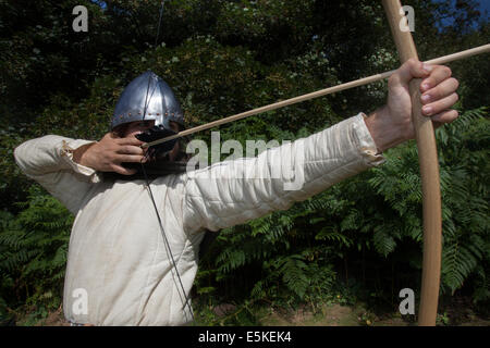 Archer prendre visent à Chester, Cheshire, Royaume-Uni 3 août, 2014. M. Dominic Tucker un longbow anglais archer avec un d'avant au tournoi de chevaliers médiévaux tenue au Château de Beeston Cheshire, Angleterre. Historia Normannis un 12ème siècle début de l'époque médiévale, l'exactitude, groupe de reconstitution se concentrer, fighter. archer, arc, arc, tir à l'arc, flèche, arme, cible, objectif, sport, tir, chasse, visant, précision, vector, Tournoi Warrior, chaîne-mail et fonctionnant à l'adrénaline des équipes d'archers armés hautement qualifiés et anglais knights répondre de front à l'English Heritage Site. Banque D'Images