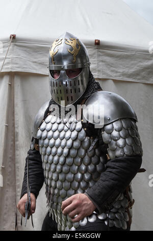 Un swordman armé dans une armure militaire complète avec un chain mail, une épée et un casque, un swordman, un combat d'épée, un guerrier, un homme, une arme, un chevalier médiéval, un chevalier traditionnel, des vêtements de protection, une martiale, un homme au château de Beeston à Cheshire, en Angleterre. Historia Normannis est un groupe de réédiction médiévale blindé datant du XIIe siècle sur le site du patrimoine anglais. Banque D'Images