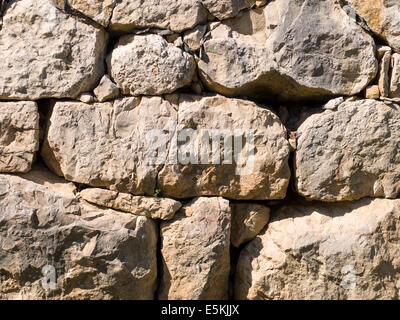 Ancien mur en pierre sèche. Les roches rugueuses composent ce mur autour de la creuser à Empuries l'ancienne ville grecque et romaine sur Costa Brava Banque D'Images