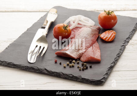 Hareng rose avec tomate, carotte, l'oignon et le poivre sur la plaque d'ardoise Banque D'Images