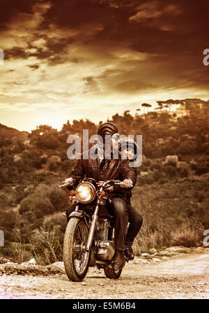 Heureux les motocyclistes sur la route dans le coucher du soleil, grunge style photo de famille active sport extrême, l'amour et l'aventure Banque D'Images