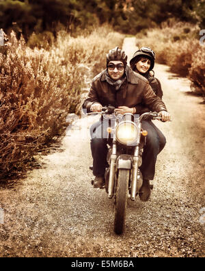 Image style vintage de deux motards heureux à cheval sur la route, voyage en famille actives sur le luxe transport extrême Banque D'Images