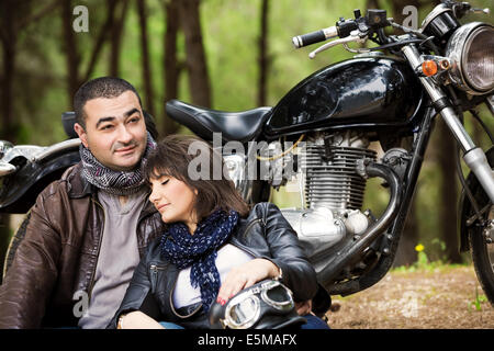 Jolie femme dormir sur les épaules de son mari, assis près de moto, bikers de détente après la visite de la forêt Banque D'Images