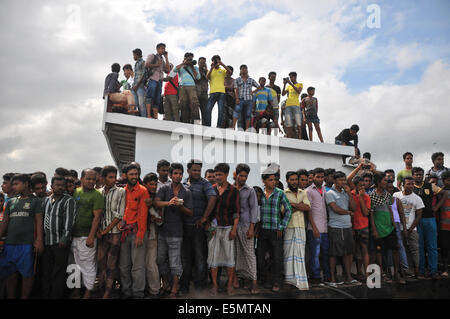 Mawa. 4e août, 2014. Les gens se rassemblent près de l'emplacement d'un accident de ferry dans le district de Munshiganj, quelque 37 km de la capitale Dhaka, Bangladesh, le 4 août 2014. Une opération de recherche est en cours après un ferry transportant 200 passagers a coulé le lundi au milieu d'un fleuve dans le quartier central de Munshiganj, a annoncé la police. Source : Xinhua/Alamy Live News Banque D'Images