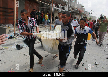 Gaza, bande de Gaza ville de Rafah. 4e août, 2014. Les Palestiniens portent le corps d'une femme morte qui a été trouvé sous les décombres d'une maison détruite, et des témoins ont déclaré que les médecins qui a été la cible d'une attaque aérienne israélienne, dans le sud de la bande de Gaza ville de Rafah, le 4 août 2014. Depuis le début de la guerre israélienne sur la bande de Gaza, 1 834 Palestiniens ont été tués et plus de 9 500 blessés, environ le tiers sont des civils, porte-parole du ministère de la santé Ashraf al-Qedra à Gaza a dit. Credit : Khaled Omar/Xinhua/Alamy Live News Banque D'Images