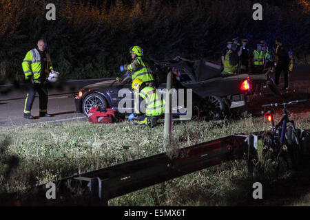 Les services d'urgence tentative de libérer un homme de sa BMW M3, qui s'est écrasé dans un grand lampadaire sur le côté de la route Banque D'Images