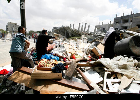 Rafah, Gaza. 4e août, 2014. La recherche de la famille palestinienne l'épave d'un bâtiment, qui a été touché à une frappe israélienne, à Rafah, dans le sud de la bande de Gaza. Israël a dit qu'il a unilatéralement maintenir le feu dans la plupart de la bande de Gaza le lundi afin de faciliter l'entrée de l'aide humanitaire et permettre à certains des centaines de milliers de Palestiniens déplacés par un près de quatre semaines, la guerre à la maison, à l'exception de Rafah n'est pas compris dans la trêve l'humanité. Credit : Abed Rahim Khatib/Pacific Press/Alamy Live News Banque D'Images