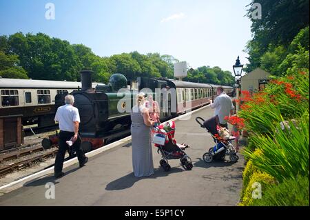 Les passagers regardent un train à vapeur arrivent à Bodmin général station sur la Bodmin et Wenford Railway, Cornwall, UK Banque D'Images