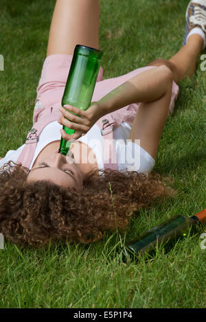 Problème d'alcool chez les adolescentes des boissons à partir de la fille une bouteille de bière Banque D'Images