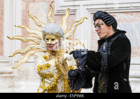 Les hommes en blanc et or et noir des costumes du xviiie siècle à l'extérieur de l'église San Zaccaria pendant le carnaval de Venise. Banque D'Images