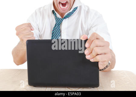 Furious businessman anonyme prêt à détruire son ordinateur portable avec fist Banque D'Images