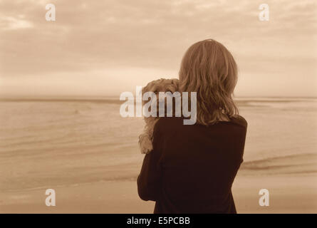 Femme avec chien de terrier de Norfolk on beach Banque D'Images