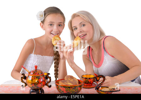 Mère et fille de manger les tartes sur le fond blanc Banque D'Images