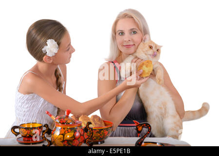 Mère et fille nourrir un chat rouge avec des tartes Banque D'Images