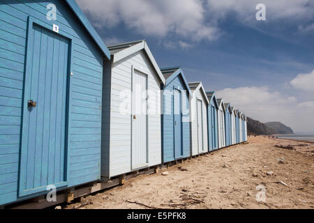 Royaume-uni l'Angleterre, dans le Dorset, Charmouth, cabines de plage peinte en bleu ci-dessous Côte Jurassique cliff Banque D'Images
