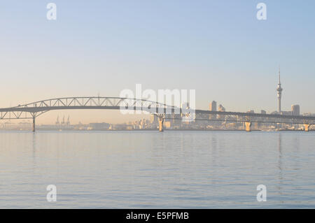 Vue sur Auckland Harbour Bridge de Birkenhead wharf in early morning light avec la CDB en arrière-plan Banque D'Images