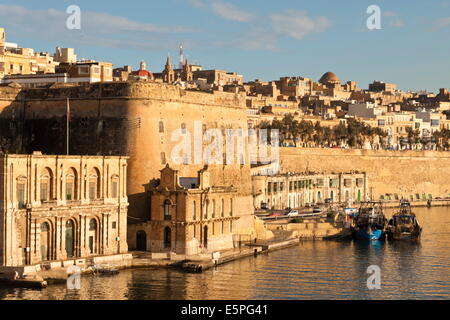 Des bateaux de pêche à quai la Barriera et le Grand Port fortifications dans les premières heures d'or, La Valette, Malte, Méditerranée Banque D'Images