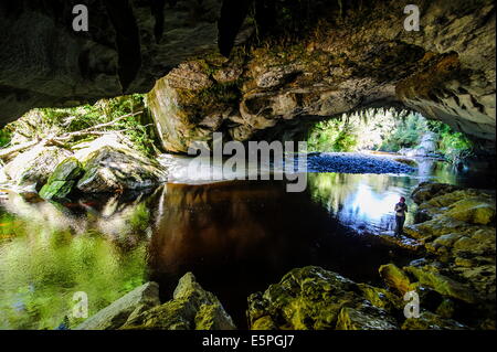 Woman la magnifique porte de la Moria Arch dans le bassin, Oparara Karamea, côte ouest, île du Sud, Nouvelle-Zélande, Pacifique Banque D'Images