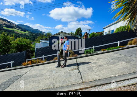 Les touristes debout sur la Rue Baldwin, la rue résidentielle la plus raide, Dunedin, Otago, île du Sud, Nouvelle-Zélande, Pacifique Banque D'Images