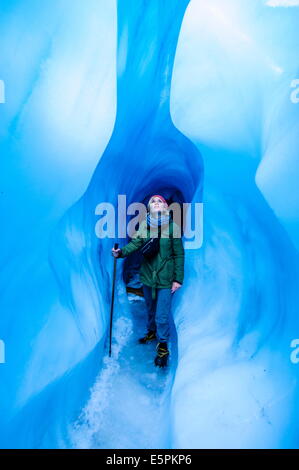 Femme debout dans une grotte de glace, Fox Glacier, Westland Tai Poutini National Park, Île du Sud, Nouvelle-Zélande, Pacifique Banque D'Images