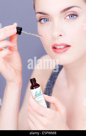 Femme à l'aide d'un remède de Bach (extrait de fleur de liquide). Banque D'Images
