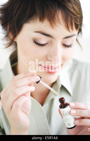 Femme à l'aide d'un Bach rescue remedy (liquide flower extract) pour réduire le stress et l'angoisse. Banque D'Images