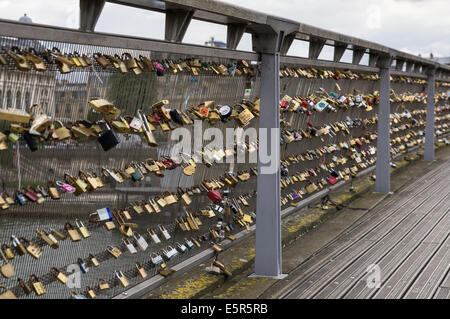 Cadenas avec noms et dates laissés par les couples sur la passerelle Léopold-Sédar-Senghor, passerelle Solférino, Paris, France Banque D'Images