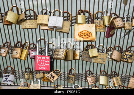 Cadenas avec noms et dates laissés par les couples sur la passerelle Léopold-Sédar-Senghor, passerelle Solférino, Paris, France Banque D'Images