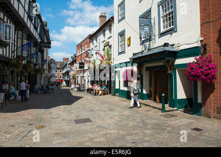 Les gens assis à l'extérieur des pubs et cafés dans Butcher Row, Shrewsbury, Shropshire, Angleterre. Banque D'Images