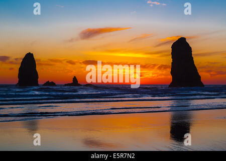 La plage de Canon les meules au coucher du soleil sur la côte de l'Oregon, USA. Banque D'Images