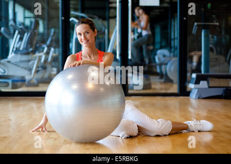 Femme avec ballon de gym dans une salle de sport. Banque D'Images