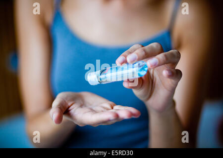 Femme avec ses mains nettoyage gel hydroalcoolique. Banque D'Images