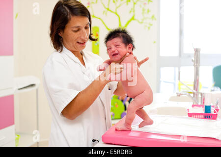 Pédiatre examinant un bébé nouveau-né (renforcement ou à pied), de l'Obstétrique et de gynécologie, Hôpital de Saintonges, Ministère Banque D'Images