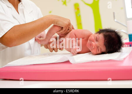 Pédiatre examinant un bébé nouveau-né, de l'Obstétrique et gynécologie, Hôpital de Saintonges, Saintes, France. Banque D'Images