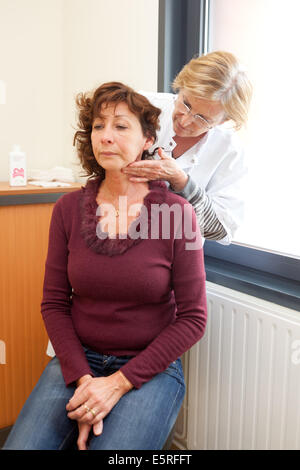 Radiothérapeute du cancer avec une patiente souffrant de cancer de la gorge en consultation pour le suivi médical après la radiothérapie Banque D'Images