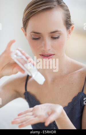 Femme lave-mains avec le gel hydroalcoolique. Banque D'Images