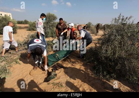 Rafah, bande de Gaza, territoire palestinien. 5e août, 2014. Les médecins portent le corps mort d'un palestinien après l'avoir sortie de sous les décombres d'une maison qui selon des témoins a été détruit pendant l'offensive israélienne, dans l'est de Rafah dans le sud de la bande de Gaza . Israël a retiré ses forces de terre en provenance de la bande de Gaza le mardi et a commencé une trêve de 72 heures avec le Hamas par l'intermédiaire de l'Égypte comme un premier pas vers des négociations sur une plus durable à la fin mois de guerre. Credit : ZUMA Press, Inc./Alamy Live News Banque D'Images