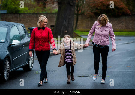 Girl walking down street holding hands with 2 femmes Banque D'Images