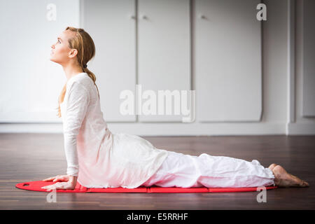 Femme pratiquant des exercices d'étirement pour soulager les maux de dos. Banque D'Images