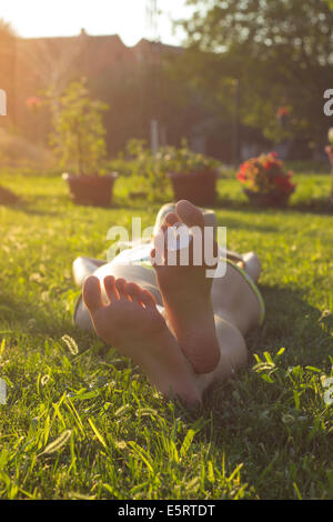 Fille allongé dans l'herbe, se détendre et profiter d'une belle journée ensoleillée Banque D'Images