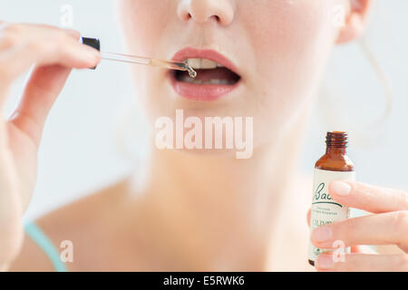 Femme à l'aide d'un remède de Bach (extrait de fleur de liquide). Banque D'Images