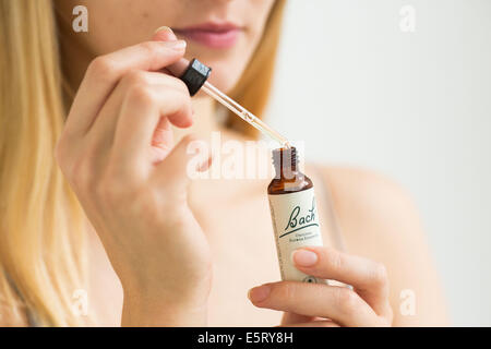 Femme à l'aide d'un remède de Bach (extrait de fleur de liquide). Banque D'Images